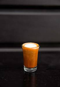 capuccino shot in fron of dark background