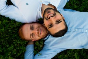 Same-sex couple lying in grass