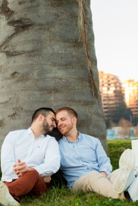 Gay couple leaning against a palm tree