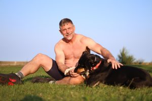Shirtless man in his 50s with dog
