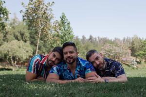 Throuple lying on grass in park