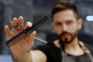 Barber holding scissors and comb