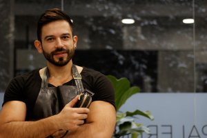 Handsome barber posing in his barbershop