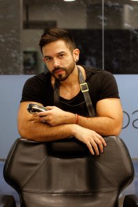 Handsome barber posing in his barbershop