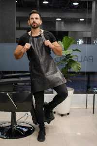 Handsome barber posing in his barbershop