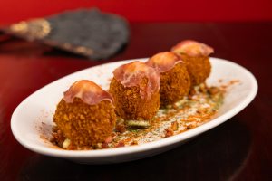Spanish croquetas with ham on a white plate.